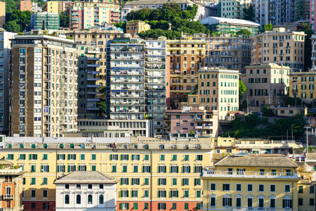 City skyline in afternoon sunlight, high-rise apartment buildings on the hillside, multilevel architecture in Genoa old town, Italyの写真素材