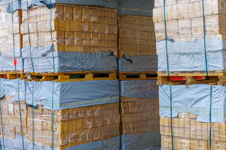 Wood chip briquettes stacked on pallets, packed in polyethylene, eco briquettes from pressed sawdust perfect for stoves and fireplaceの写真素材