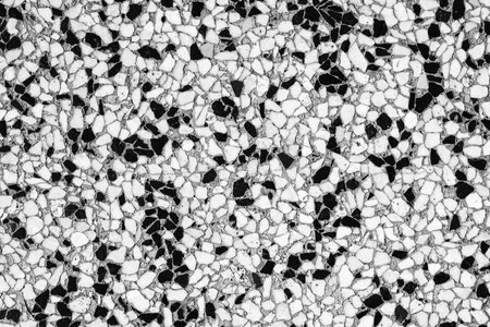 Abstract patterned mosaic of white and black small irregularly shaped stones, black and white backgroundの写真素材