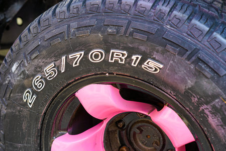 Detailed Close-Up of a 265-70R15 Tire Mounted on a Bold Pink Rim, Highlighting Tread Pattern and...