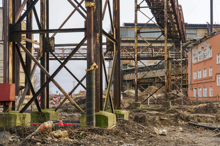 Rusted steel supports and derelict industrial buildings dominate this urban construction site undergoing renewal and transformationの写真素材