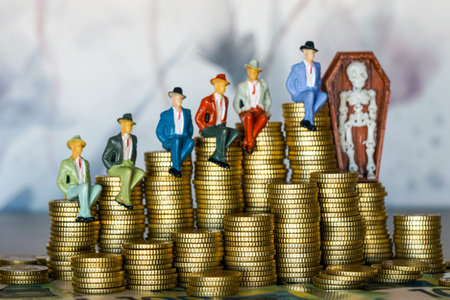 Miniature businessmen figurines sit on stacks of coins beside a skeleton in coffin, symbolizing...