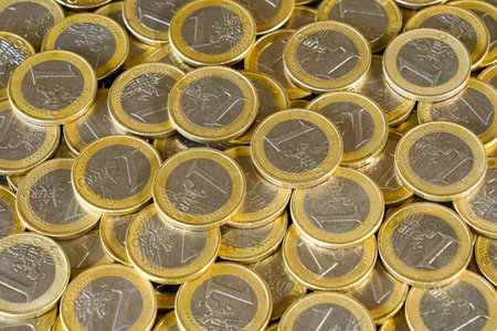 One euro coins scattered and stacked together, representing European currency, economy, savings, banking, and financial stability in the eurozoneの写真素材
