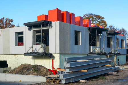 New apartment building under construction featuring precast concrete walls, thermal insulation, steel beams, and construction materials at urban siteの写真素材