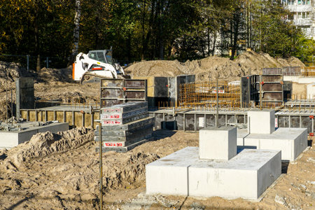 Reinforced concrete foundations and steel framework of a new apartment building under construction, showing the early phase of residential developmentの写真素材