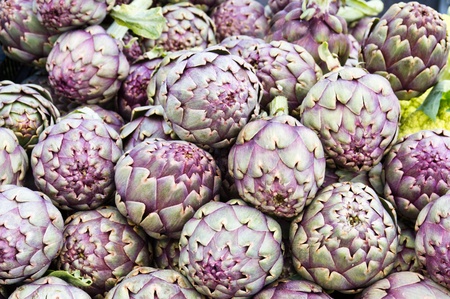 Freshly harvested red artichokes on display at the farmers marketの写真素材