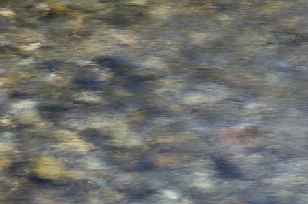 Rippled background showing pebbles through clear waterの写真素材
