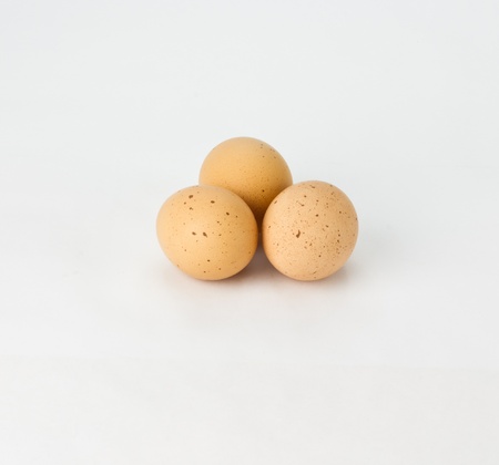 Three fresh free range speckled brown eggs on whiteの写真素材