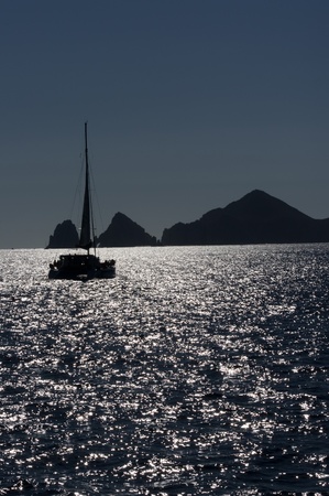 A sail boat heads for port as darkness gathers off the coast of Cabo san Lucasの写真素材