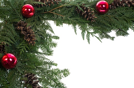 A decorative border of pine boughs ornaments cones isolated on whiteの写真素材