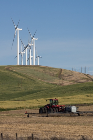 Wind turbines compete with traditional farmingの写真素材