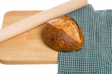 A loaf of bread with rolling pin and cutting boardの写真素材