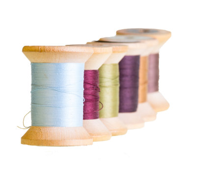 Row of wooden sewing thread spools