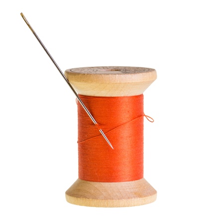 Spool of orange thread with a needle isolatedの写真素材