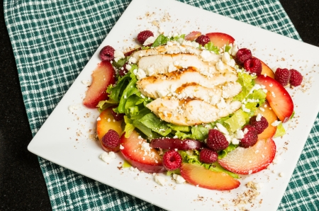 Fresh grilled chicken salad with plums and raspberriesの写真素材