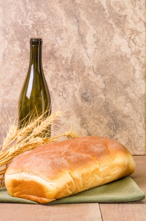 A loaf of fresh wheat bread with a wine bottleの写真素材