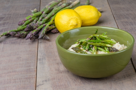 Bowl of fresh asparagus risotto with asparagus spears and lemonsの写真素材