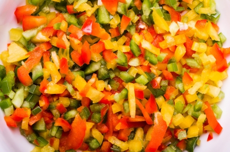 A bowl of freshly diced red yellow and green peppersの写真素材