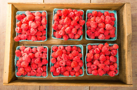 Freshly picked red raspberries on display at the farmers market