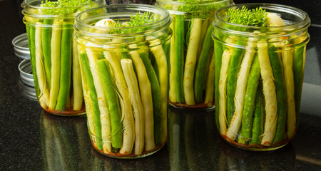 Fresh green and yellow beans being processed into jars for preserving or canningの写真素材