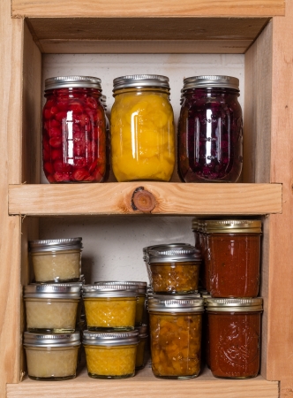 Storage shelves in pantry with homemade canned preserved fruits and vegetablesの写真素材