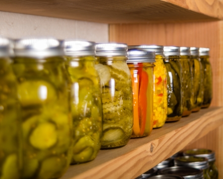 Canned goods on wooden storage shelves in pantryの写真素材