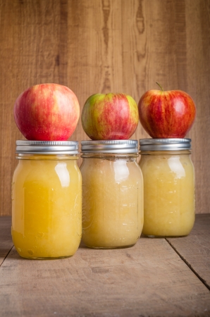 Jars of canned applesauce with fresh applesの写真素材