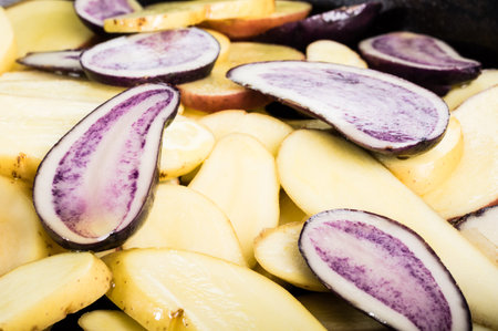Potato slices in frying pan both white and blueの写真素材