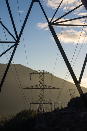 Dawn view through a line of transmission towersの写真素材