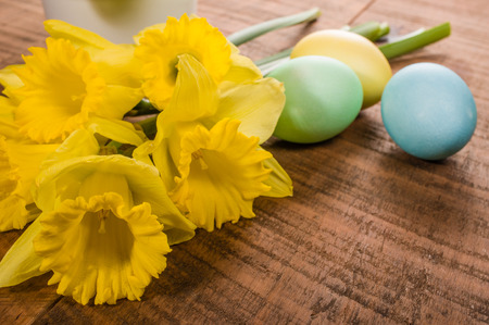 Yellow daffodils and colorful dyed Easter eggsの写真素材