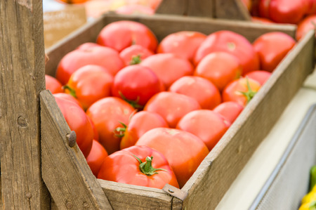 Wooden box display of red ripe tomatoes at the marketの写真素材