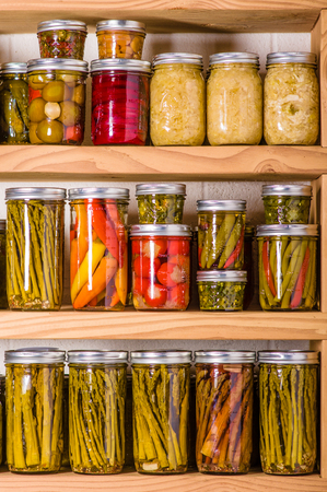 Pantry shelves loaded with jars of pickled vegetablesの写真素材