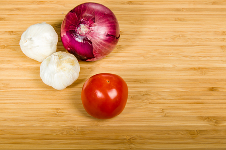 Tomato with cloves of garlic and a red onionの写真素材