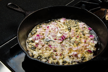 Carmelizing cut red onions in a cast iron skilletの写真素材