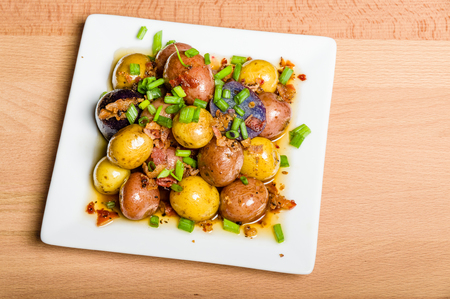 Fresh new potatoes boiled and dressed to serve on a white plateの写真素材