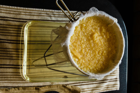 Straining apple sauce to make apple juice with cheese cloth