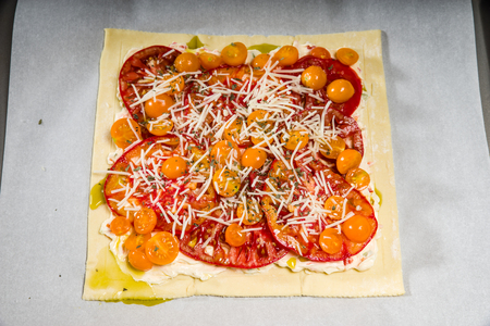 Fresh homemade tomato pizza ready for bakingの写真素材