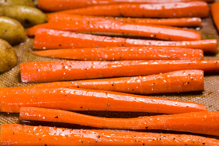 Fresh orange carrots on a baking sheet ready for the ovenの写真素材