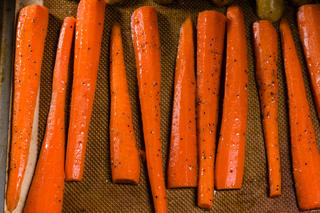 Fresh orange carrots on a baking sheet ready for the ovenの写真素材