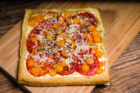 Homemade warm baked tomato pizza with red and yellow tomatoesの写真素材