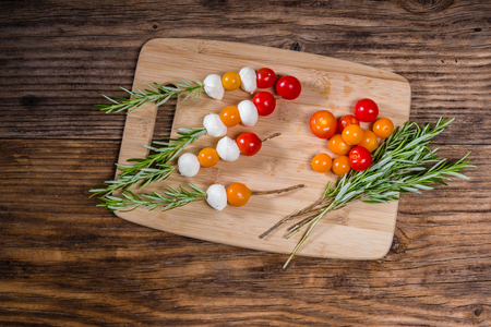 Tomatoes and cheese balls on rosemary skewersの写真素材