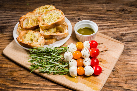 Tomato cheese and bread appetizers on rosemary skewersの写真素材