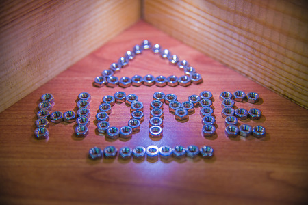 Inscription Home on wooden background. Laid out nuts inscription tree house.の写真素材