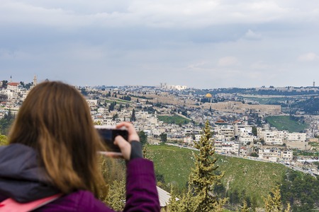 Woman taking photograph with smartphone at enjoying view of Jerusalemの写真素材