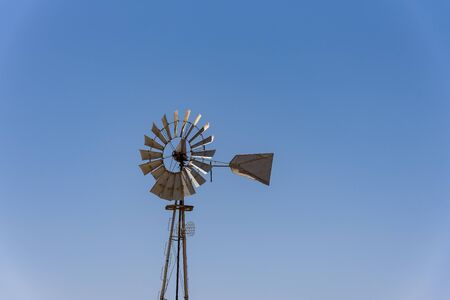 An old windmill against a blue sky in the town of Sutherland The windmill is metal. Cyprusの写真素材