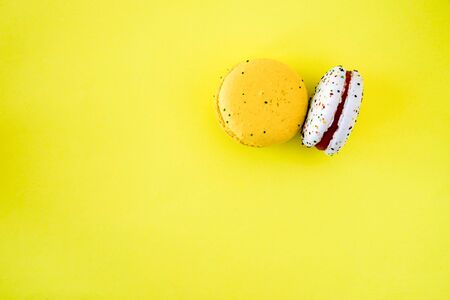 Macaroons presented inside french multi-colored cookies makoorons on a yellow backgroundの写真素材