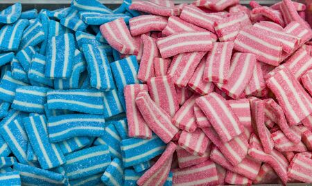 Different fruit candies. Colorful bright chewy candies covered with sugar. Rainbow ribbon candies. Colorful jelly candies close up as a bright joyful background. Top view. Candy background.の写真素材