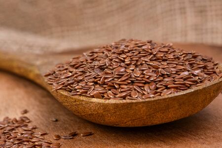 Flax seeds pouring end rotating in slow motion. Flax seeds in a wooden spoon.の写真素材