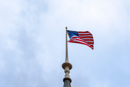 American flag waving in blue sky. American flag at the top.