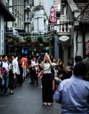 young girl taking photo of Shanghai Tianzifang street viewのeditorial素材